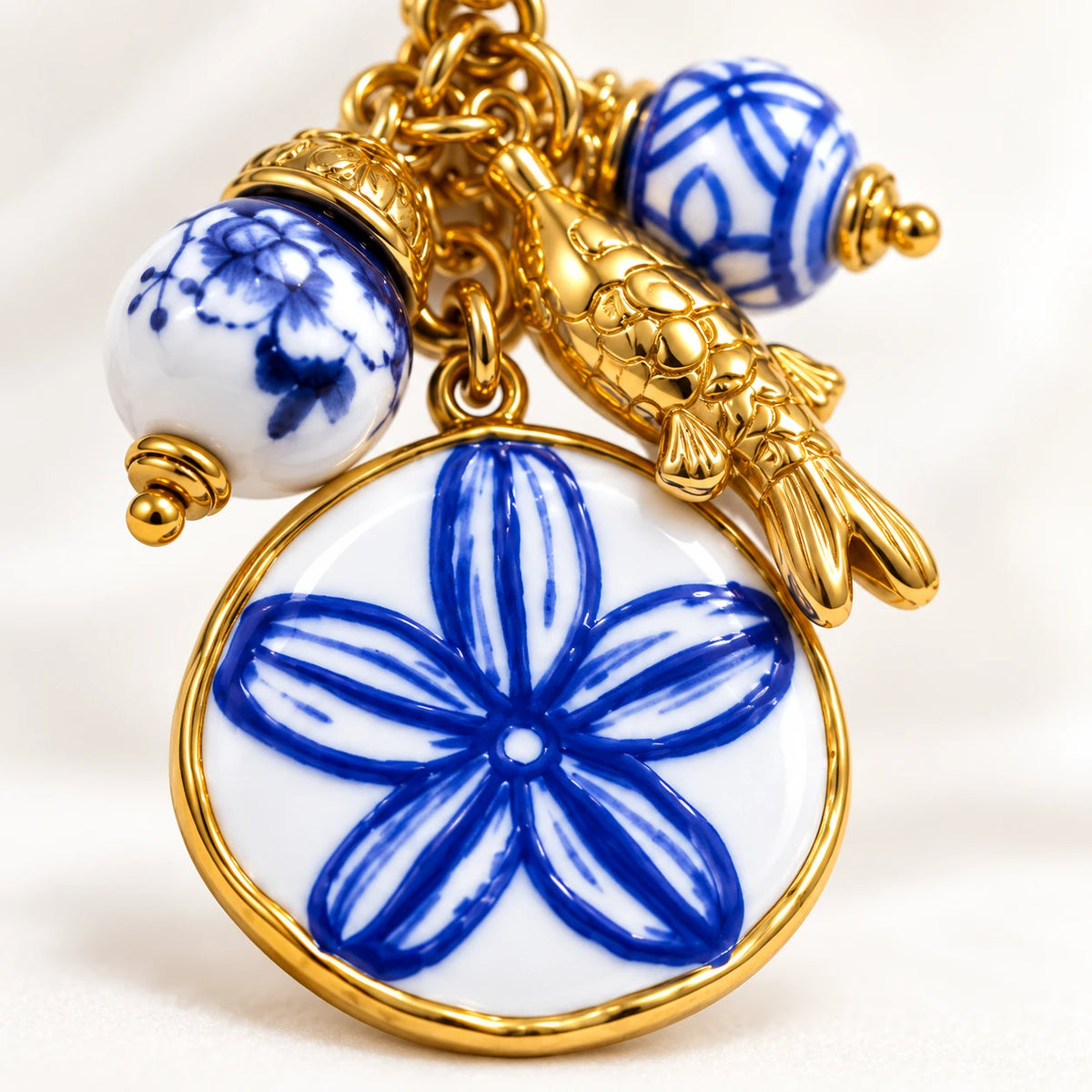 Medallón circular de cerámica con flor cobalto y pez en PVD de oro 18K — Alquimia Cobalt, The Wolf Concept